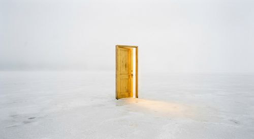 Minimalist golden door in a vast white space symbolizing financial freedom