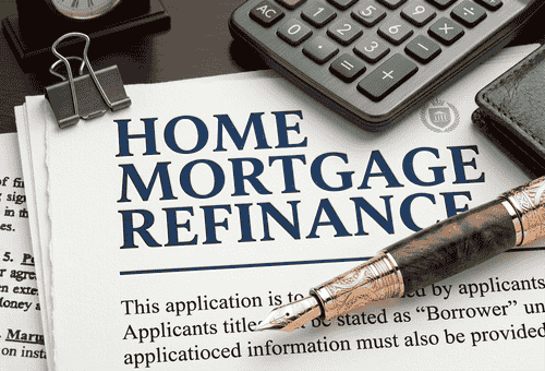 Close-up of a Home Mortgage Refinance application document with a fountain pen and calculator